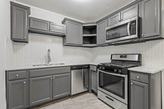 kitchen featuring a sink, open shelves, gray cabinetry, and stainless steel appliances