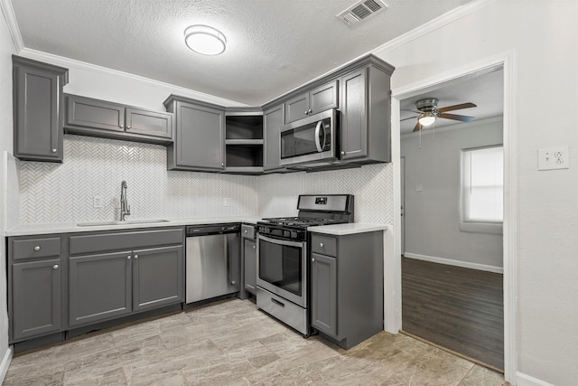 kitchen with visible vents, ornamental molding, open shelves, stainless steel appliances, and light countertops