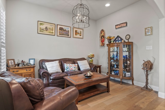 living room with an inviting chandelier, recessed lighting, baseboards, and light wood finished floors