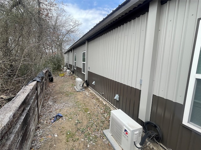 view of home's exterior with metal roof and ac unit