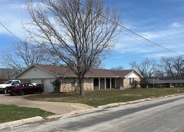 ranch-style house featuring brick siding, board and batten siding, a front lawn, driveway, and an attached garage