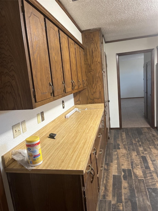 kitchen featuring a textured ceiling, light countertops, and dark wood-style flooring