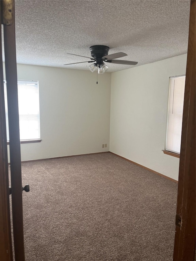 carpeted empty room featuring ceiling fan, baseboards, and a textured ceiling