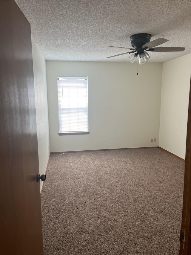 empty room with a textured ceiling, carpet, and a ceiling fan