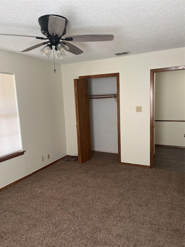 unfurnished bedroom with a ceiling fan, visible vents, a closet, a textured ceiling, and carpet flooring