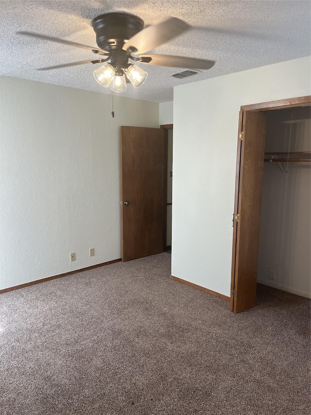 unfurnished bedroom with baseboards, visible vents, a closet, a textured ceiling, and carpet flooring