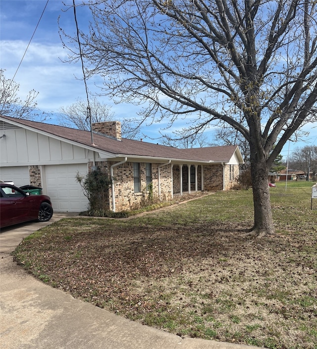 ranch-style house with a front yard, an attached garage, a chimney, concrete driveway, and brick siding