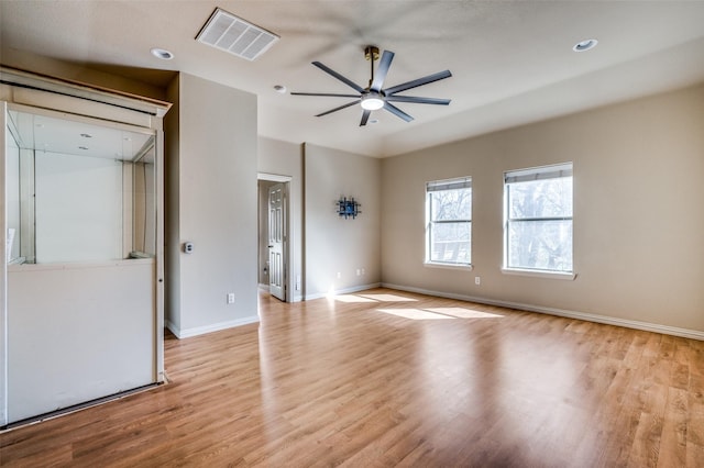 empty room with baseboards, light wood-style floors, visible vents, and ceiling fan