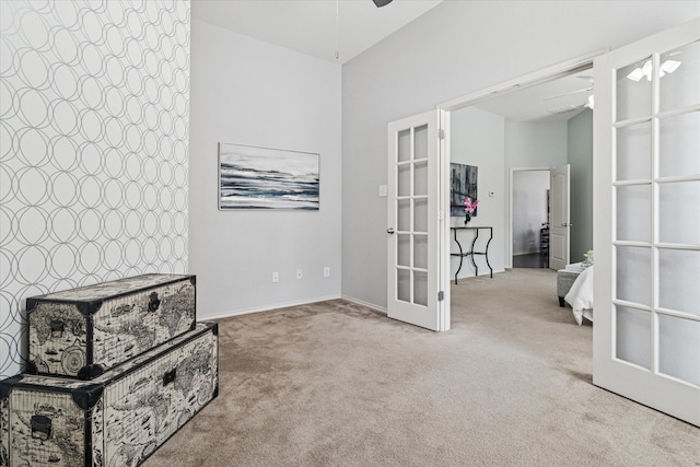 living area with french doors, carpet, and ceiling fan