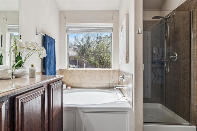 full bathroom with vanity, a shower stall, a garden tub, and a wealth of natural light