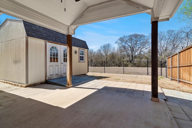 view of patio with an outdoor structure, a fenced backyard, and a ceiling fan