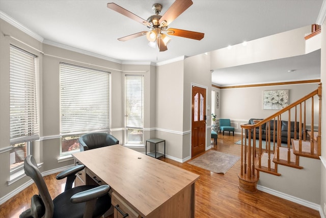 office space with baseboards, crown molding, a ceiling fan, and wood finished floors