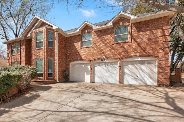 view of front facade with brick siding, driveway, and an attached garage