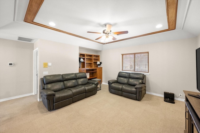 living room with visible vents, a raised ceiling, light carpet, and ceiling fan