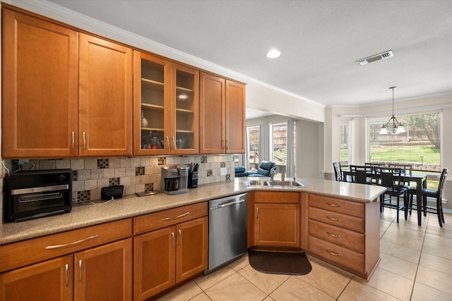 kitchen featuring visible vents, a peninsula, a sink, dishwasher, and tasteful backsplash