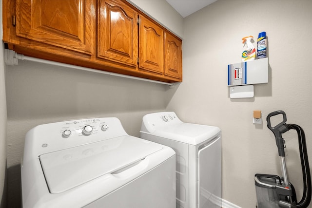 clothes washing area with cabinet space and washer and clothes dryer