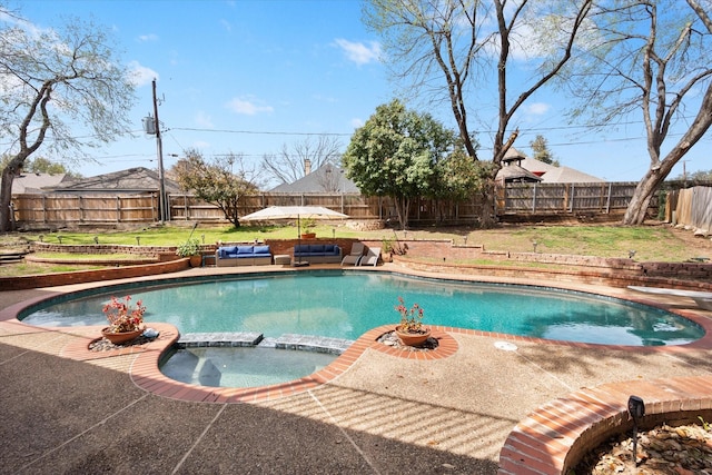 view of swimming pool featuring a lawn, a pool with connected hot tub, a patio, a fenced backyard, and a diving board