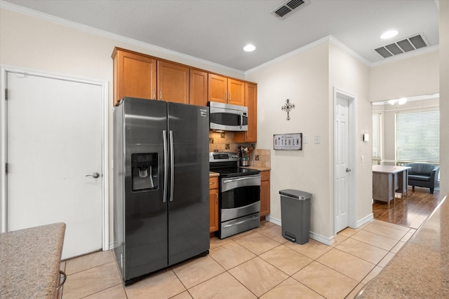 kitchen featuring visible vents, stainless steel appliances, brown cabinetry, light tile patterned floors, and decorative backsplash