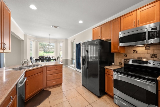 kitchen with visible vents, a sink, stainless steel appliances, crown molding, and tasteful backsplash