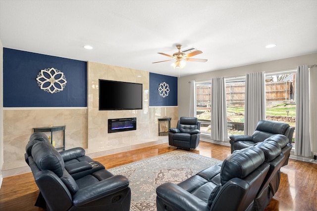 living room featuring ceiling fan, wood finished floors, recessed lighting, and a tile fireplace