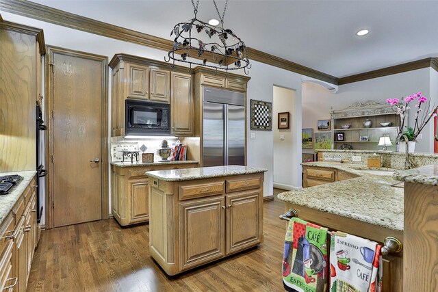 kitchen featuring black appliances, a center island, dark wood-style floors, and a sink