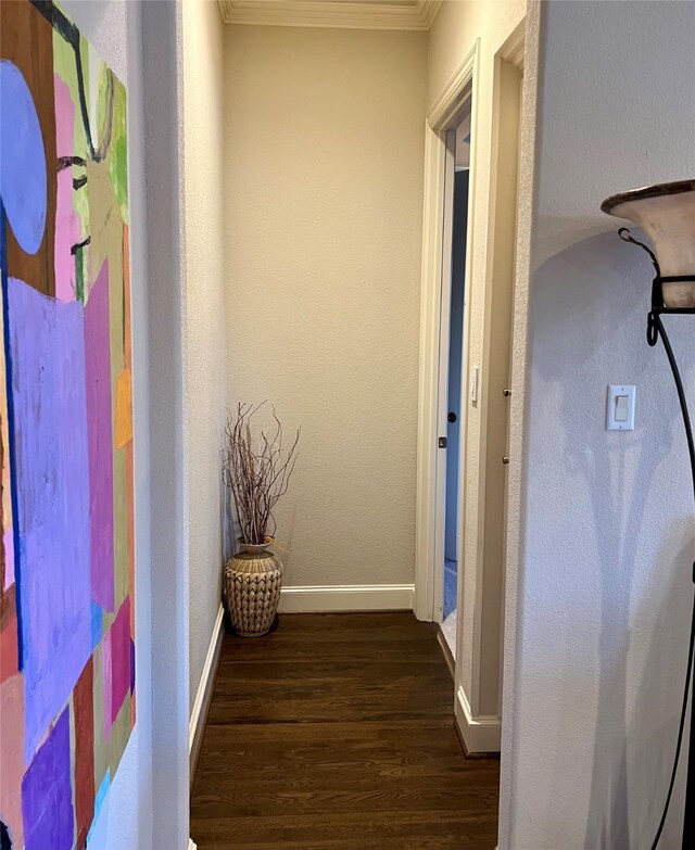 corridor with dark wood finished floors, baseboards, and ornamental molding