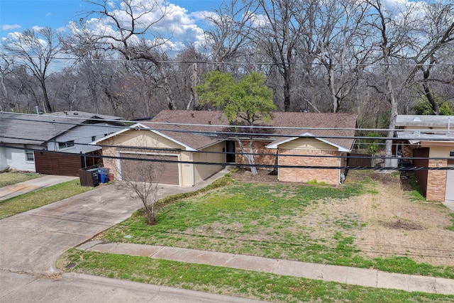 single story home with a front yard, a garage, and driveway