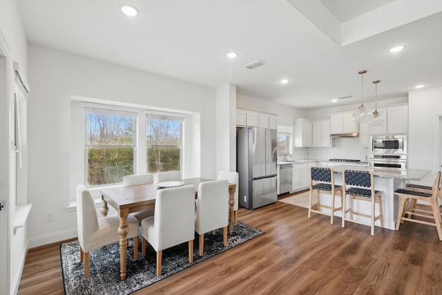 dining space featuring recessed lighting, visible vents, baseboards, and wood finished floors