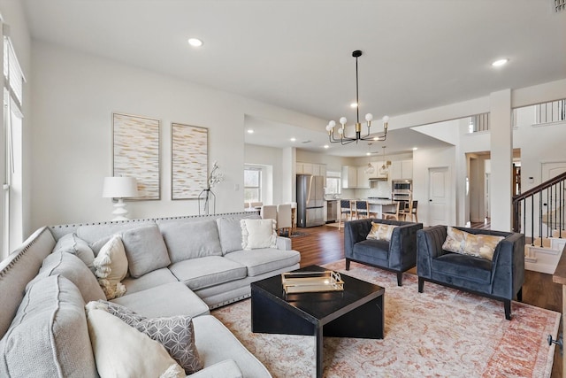 living area featuring a notable chandelier, stairway, recessed lighting, and dark wood-type flooring