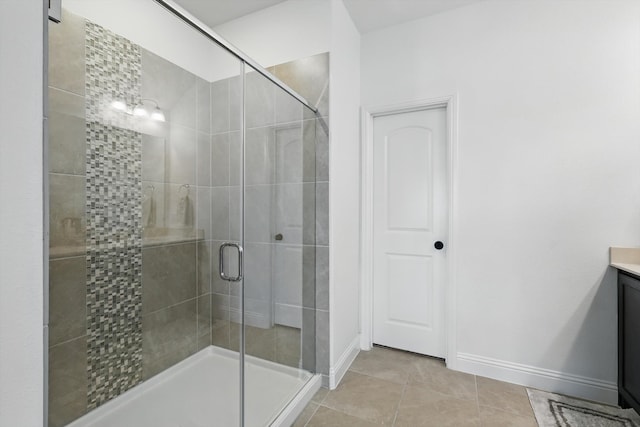 full bathroom featuring tile patterned flooring, vanity, a stall shower, and baseboards