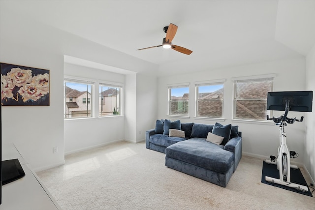 living area with a wealth of natural light, baseboards, carpet floors, and a ceiling fan