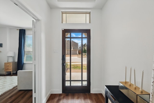 foyer entrance with a wealth of natural light, baseboards, and dark wood-style floors