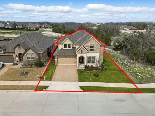 french country inspired facade featuring driveway, brick siding, a front lawn, a garage, and a residential view