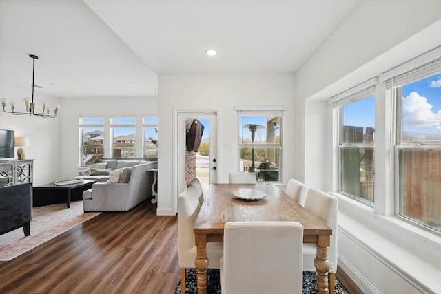 dining room featuring dark wood-type flooring, recessed lighting, a healthy amount of sunlight, and a chandelier