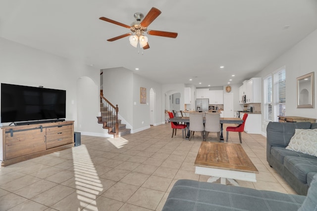 living room with recessed lighting, stairway, arched walkways, light tile patterned floors, and baseboards