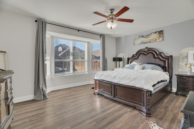 bedroom with ceiling fan, baseboards, and wood finished floors