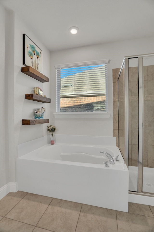 bathroom featuring tile patterned flooring, a garden tub, and a stall shower