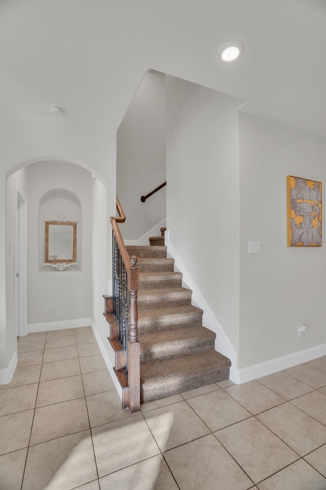 staircase featuring tile patterned flooring and baseboards