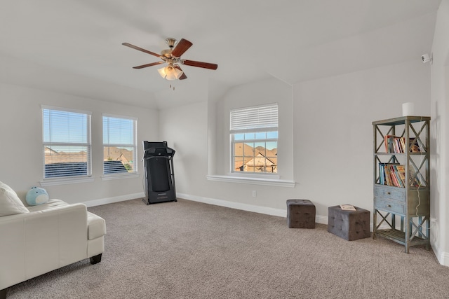 living area featuring carpet flooring, a ceiling fan, baseboards, and a wealth of natural light