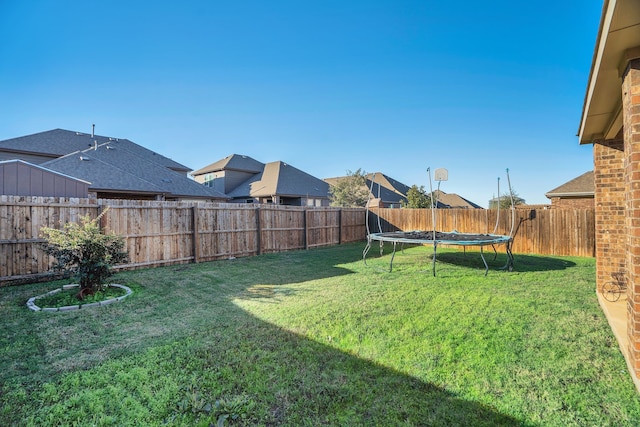 view of yard with a fenced backyard and a trampoline