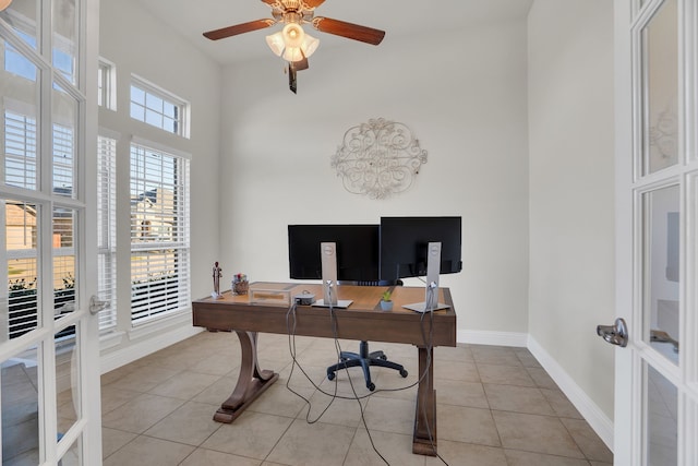 office with french doors, a high ceiling, light tile patterned floors, baseboards, and ceiling fan