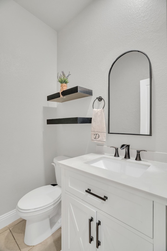 bathroom featuring vanity, tile patterned floors, toilet, and baseboards