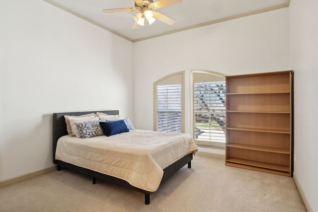 carpeted bedroom featuring a ceiling fan, crown molding, and baseboards