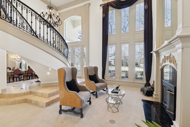 living area with stairway, a healthy amount of sunlight, a chandelier, and a towering ceiling