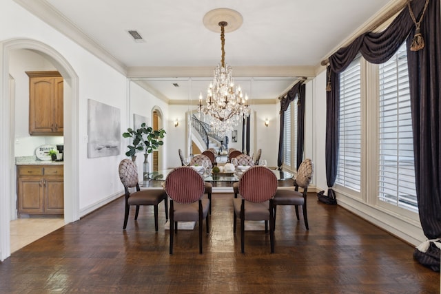 dining room featuring crown molding, a notable chandelier, a healthy amount of sunlight, and visible vents