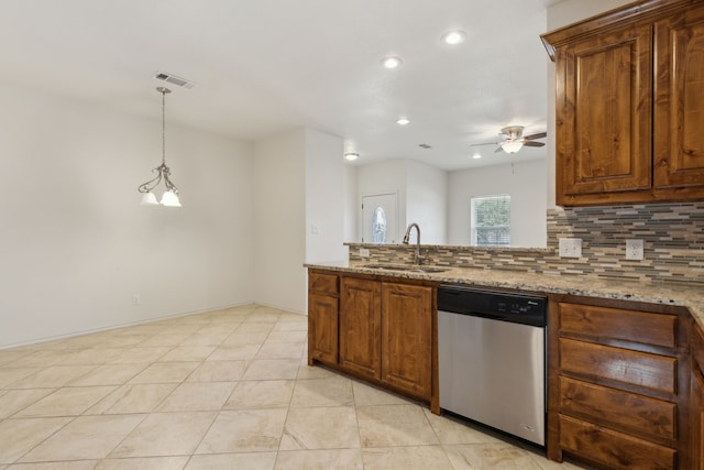 kitchen featuring visible vents, a sink, light stone counters, tasteful backsplash, and dishwasher