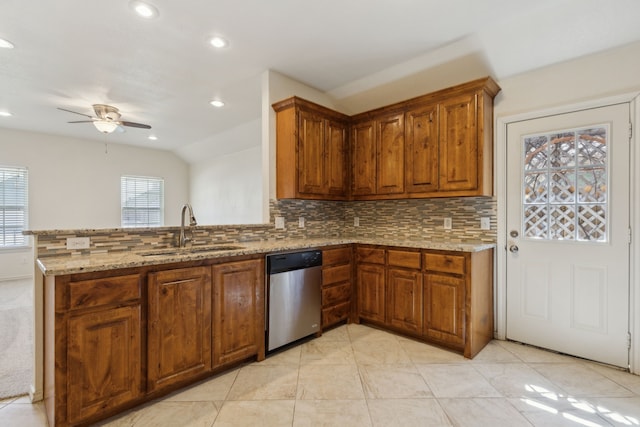 kitchen with stainless steel dishwasher, brown cabinetry, and a sink