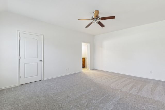 unfurnished room with baseboards, light carpet, lofted ceiling, and a ceiling fan