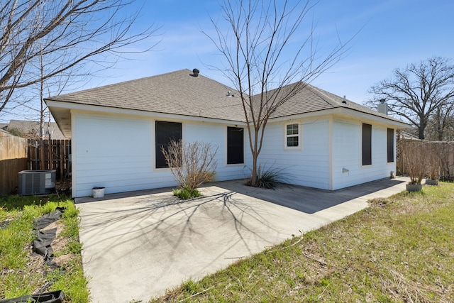 rear view of house with a patio area, fence, central AC, and roof with shingles