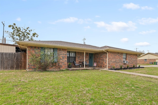 ranch-style home with brick siding, cooling unit, a front yard, and fence